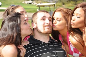 guy surrounded by girls kissing him